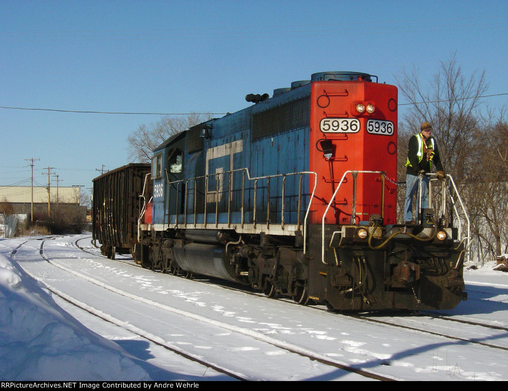 The conductor keeps watch as the little train nears the WSOR yard